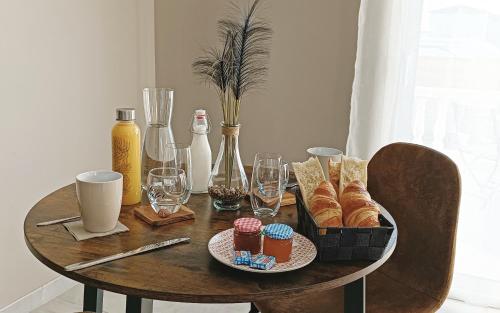 Una mesa con un plato de pasteles y vasos encima. en Villa sémaphore, suite la Fleur de Sel, en Salin-de-Giraud