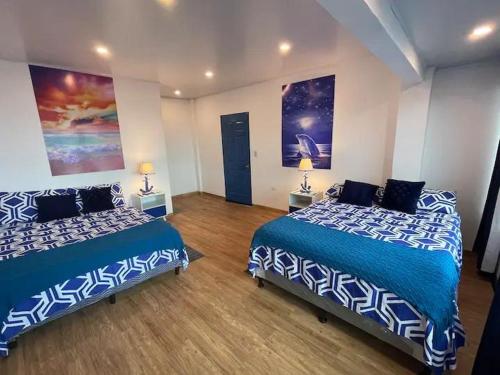 Una habitación con dos camas con sábanas azules y blancas. en Surf City-Atami Solárium beach house near el Tunco, en Tamanique