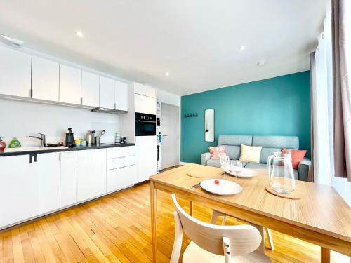 une cuisine et une salle à manger avec une table et des chaises dans l'établissement Les Alizés - Balcon - Climatisation, à Lorient