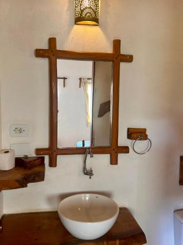 a bathroom with a bowl sink and a mirror at Pousada Maresia in Atins