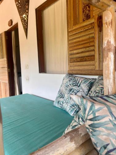 an empty bed in a room with a mirror at Pousada Maresia in Atins