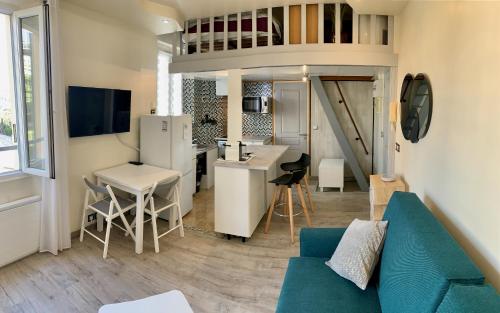 un salon avec un canapé bleu et une cuisine dans l'établissement Studio Hyper Centre - Idéal pour vos vacances ou voyage d'affaires, à Cannes