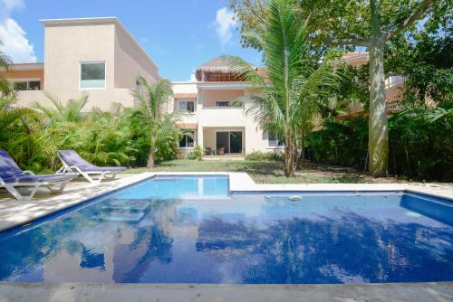 a swimming pool in front of a house at Villas Picalu Lodge in Puerto Aventuras