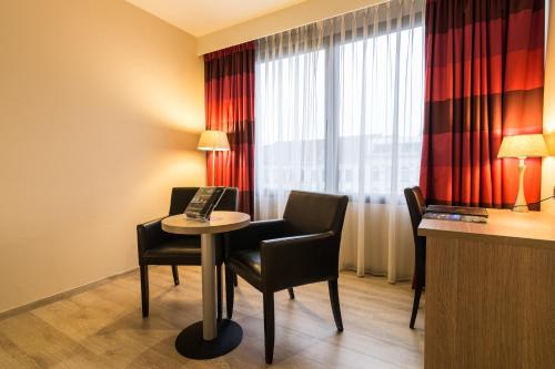 a hotel room with a table and chairs and a window at De Keyser Hotel in Antwerp