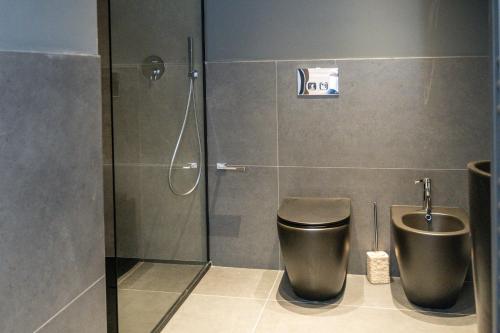 a bathroom with a shower stall with a toilet at Bellavista Kamarina Resort in Scoglitti