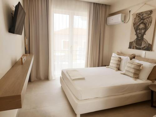 a bedroom with a white bed and a large window at Akrogiali in Skala