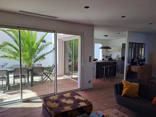 - un salon avec une porte coulissante en verre offrant une vue sur l'océan dans l'établissement Maison moderne, près des plages et de la forêt., à Anglet