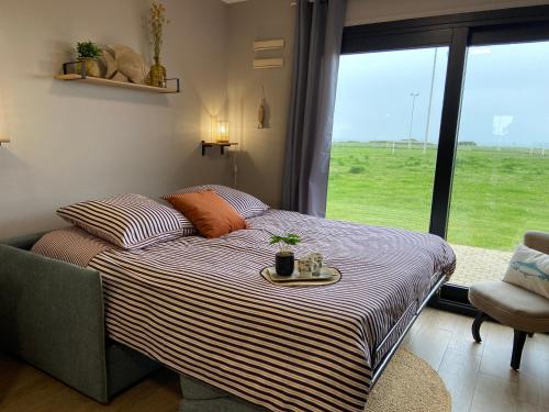 un lit avec un plateau dessus dans une pièce avec une fenêtre dans l'établissement Brise de mer sur la naturelle, Studio à Wimereux , parking, à Wimereux