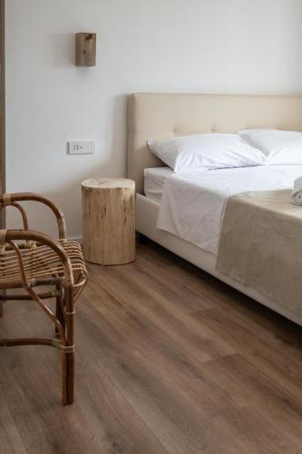 a bedroom with a bed and a chair and a table at Bellavista Kamarina Resort in Scoglitti