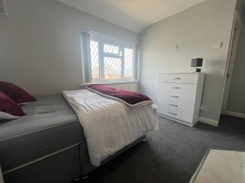 a bedroom with a bed with a dresser and a window at Premium Studio Apartment In Birmingham in Birmingham