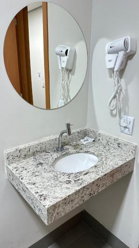 a bathroom with a sink and a mirror at Hotel Fly - Aeroporto Cuiabá in Várzea Grande