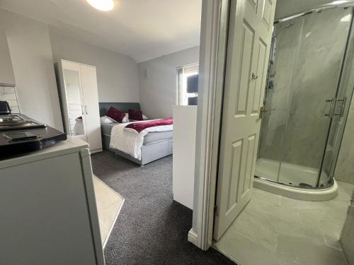 ein Bad mit einer Dusche und ein Schlafzimmer mit einem Bett in der Unterkunft Premium Studio Apartment In Birmingham in Birmingham