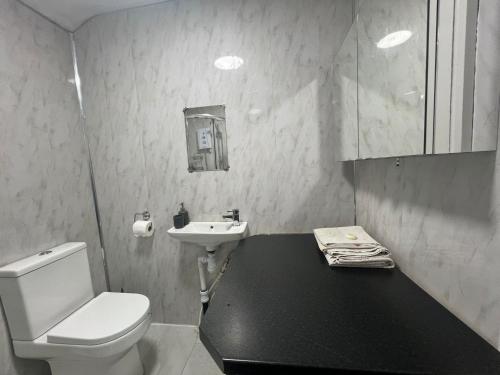 a bathroom with a white toilet and a sink at Premium Studio Apartment In Birmingham in Birmingham