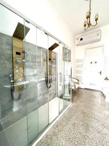 a bathroom with a glass shower with a chandelier at Stile Libero Guest House in Turin
