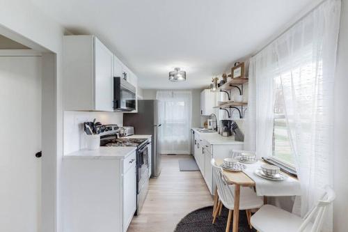 a kitchen with white cabinets and a table and a table and chairs at Touchdown Bungalow-Charming HOF Village Home in Canton