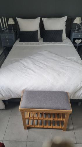 a bed with a bench sitting on top of it at Hôtel restaurant du Commerce in Poulainville