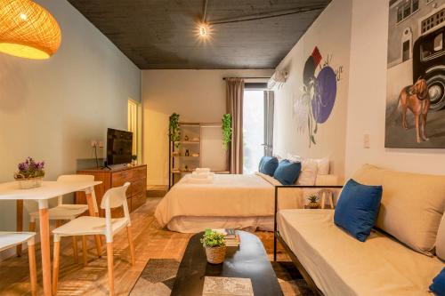 1 dormitorio con 2 camas y sala de estar en Fliphaus Chic Haus - 9 Lux Units 36 Pax en Buenos Aires