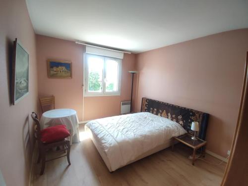 une chambre avec un lit, une table et une fenêtre dans l'établissement Appartement Orsay Grand Paris, à Orsay