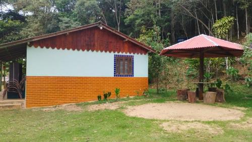 een klein huis met een oranje en wit bij Sítio Recanto Amado. in Santa Teresa