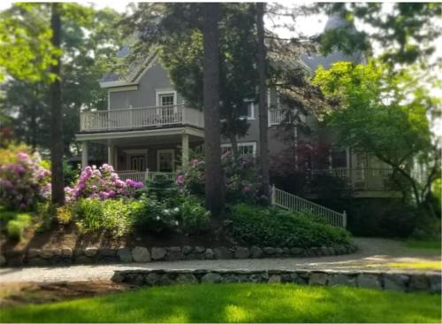 a house with flowers in front of it at Harvard House-The Gathering Place in Waltham