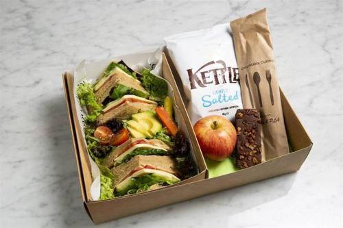 a lunch box with a sandwich and apples and nuts at Harvard House-The Gathering Place in Waltham