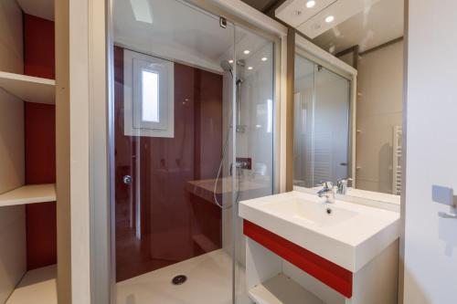 une salle de bain avec un lavabo et une douche dans l'établissement Les Demeures du Lac, à Saint-Rémy-sur-Durolle