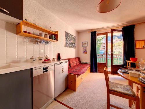 une cuisine et un salon avec un canapé et une table dans l'établissement Appartement lumineux A proximité des pistes Balcon - FR-1-344-929, à Saint-Martin-de-Belleville