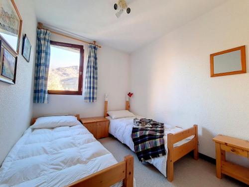 une chambre avec deux lits et une fenêtre dans l'établissement Appartement lumineux A proximité des pistes Balcon - FR-1-344-929, à Saint-Martin-de-Belleville