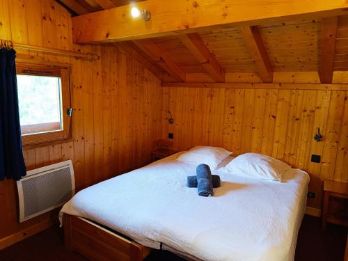 une chambre avec un lit avec un ours en peluche dessus dans l'établissement Le Mazot des Tacounets, à Saint-Gervais-les-Bains