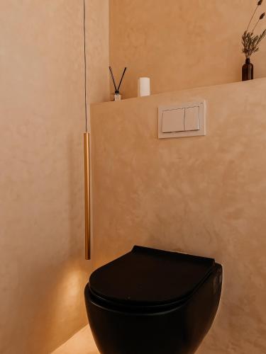 a black toilet sitting next to a wall at ALNA mogador in Akermoud