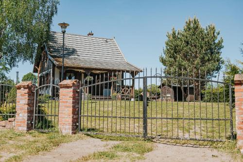 an old gate in front of a house at Rajski Domek nad Jeziorem Radacz in Borne Sulinowo