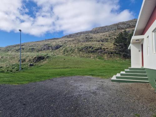 a house with stairs and a hill in the background at Helgafell Guesthouse in Stykkishólmur