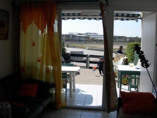 - un salon avec une porte s'ouvrant sur une terrasse dans l'établissement Appartement dans résidence pour 4 personnes à Port Camargue Le Grau-du-Roi, au Grau-du-Roi