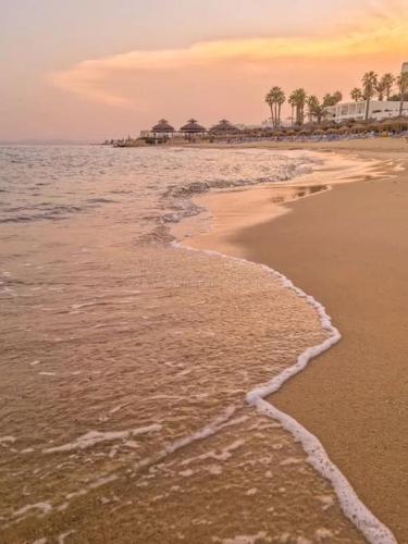 a beach with the ocean and buildings in the background at Vue sur Mer in Nabeul