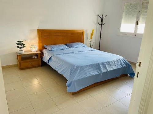 a bedroom with a bed with a blue comforter at Vue sur Mer in Nabeul