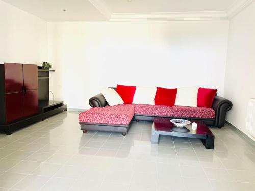 a living room with a red couch and a tv at Vue sur Mer in Nabeul