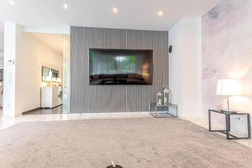 a living room with a flat screen tv on a wall at Luxury Vienna 6BR Villa with Private Pool & Sauna - Pets allowed in Vienna