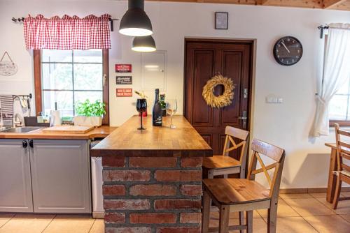 a kitchen with a table and chairs and a counter at Rajski Domek nad Jeziorem Radacz in Borne Sulinowo