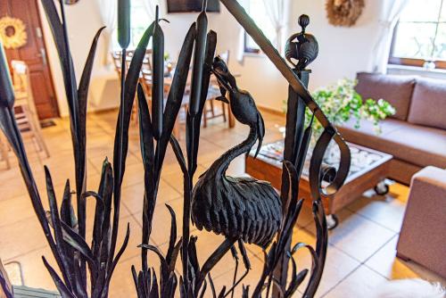 a statue of two birds on a plant in a living room at Rajski Domek nad Jeziorem Radacz in Borne Sulinowo