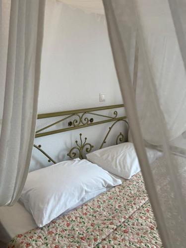 a bed with a canopy with two pillows on it at Nepheli in Paralia Katerinis