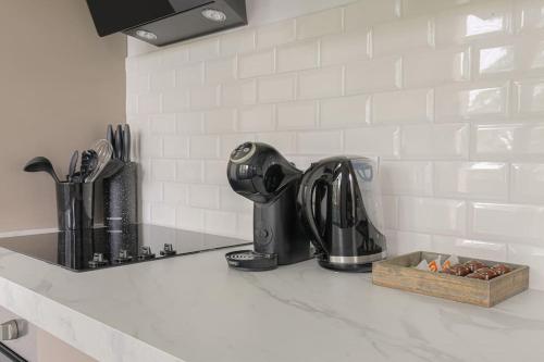 - un comptoir de cuisine avec évier et cafetière dans l'établissement Le Pressensé, idéal séjour pro ou familiale, à Vénissieux