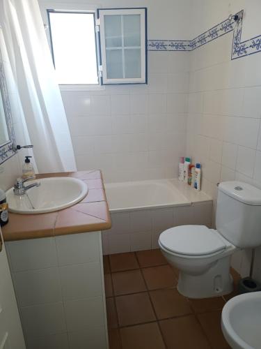 y baño con aseo, lavabo y bañera. en Islantilla Club Golf, en Huelva