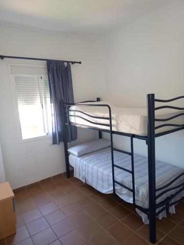 1 dormitorio con 2 literas y ventana en Islantilla Club Golf, en Huelva