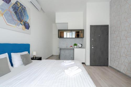 1 dormitorio con 1 cama blanca y cocina en Smart App near Railway Station Kvartet 3C en Kiev