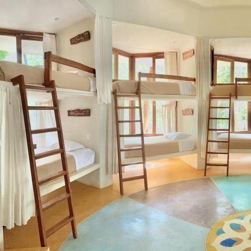 a room with four bunk beds in a house at Hotel Holistika Tulum in Tulum