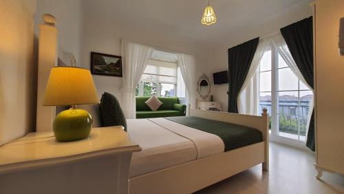 アラカティにあるAdelfia Hotelのベッドルーム1室(ランプとソファ付きのベッド1台付)