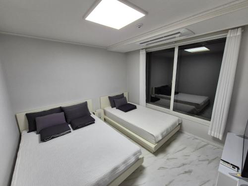 a small room with two beds and a window at JW's Bukhansan Healing Stay Ill in Seoul