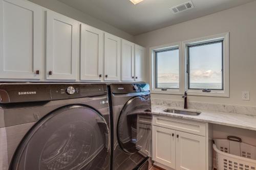 a washing machine in a kitchen with white cabinets at Luxe Home with Panoramic Greers Ferry Lake Views in Heber Springs