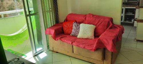 a red couch with pillows on it in a room at Ilhéus Temporada in Ilhéus