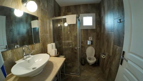 a bathroom with a sink and a shower and a toilet at Adelfia Hotel in Alaçatı